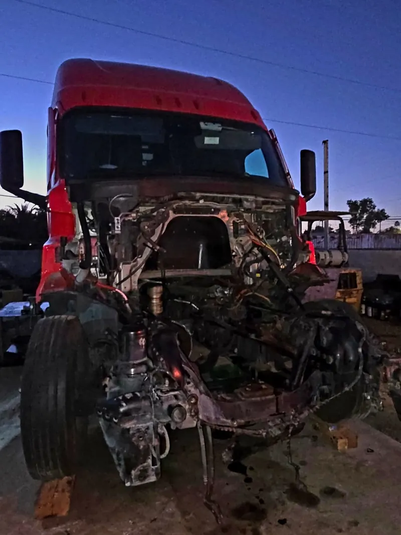 Red semi truck with engine removed for repair